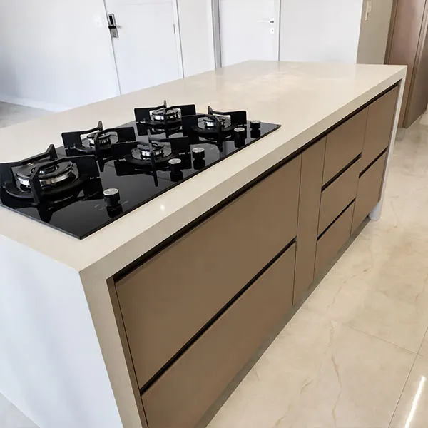 Ilha de cozinha planejada em tom café com cooktop cinco bocas e bancada em quartzo bege