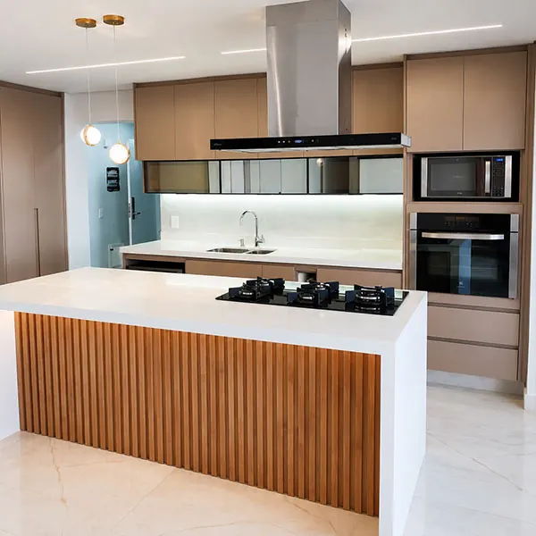 Cozinha planejada com ilha central, frontal ripado em madeira, cooktop e coifa de inox